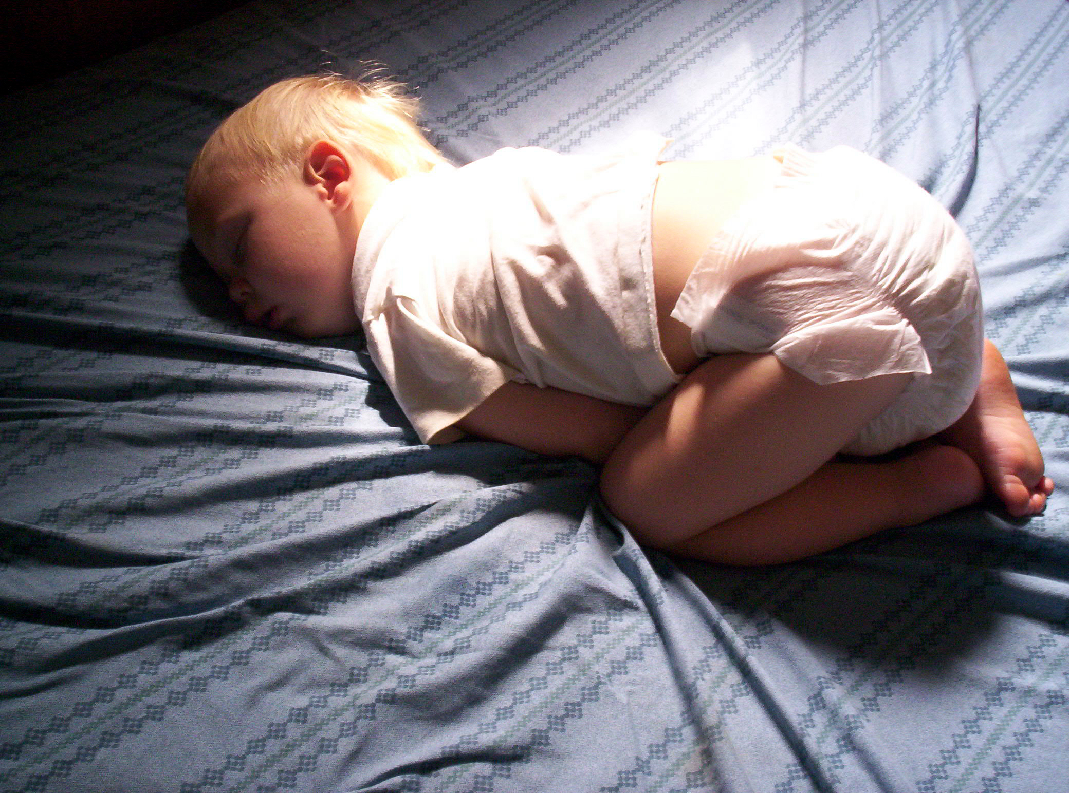 Почему ребенок лежит на животе. Спящий ребенок. Позы спящих младенцев.